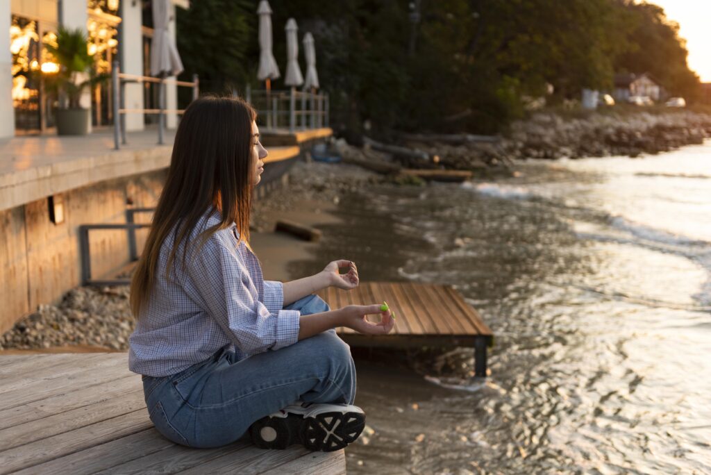 Person meditating by a calm lake, reconnecting within to rebuild life after feeling stuck.